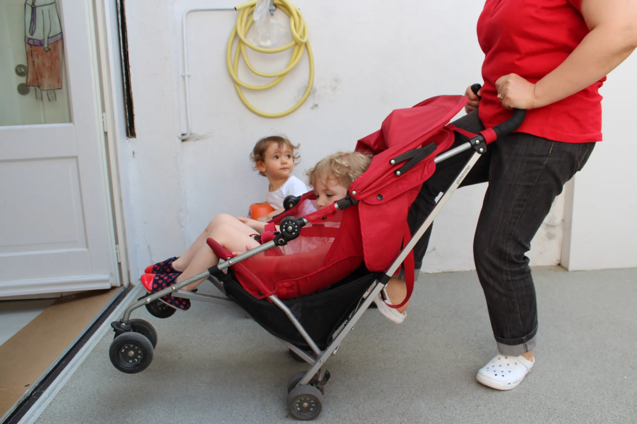 poussette-enfants Une éducatrice pousse une poussette avec des enfants.